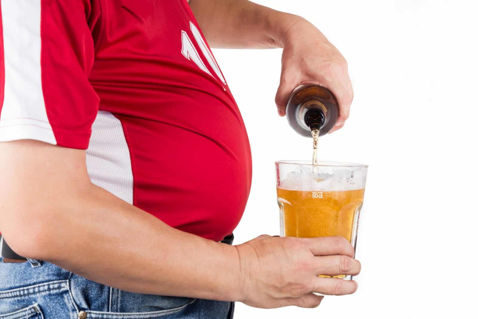 a man with a beer belly pouring a beer. This was before he knew anything about the 21 day weight loss program