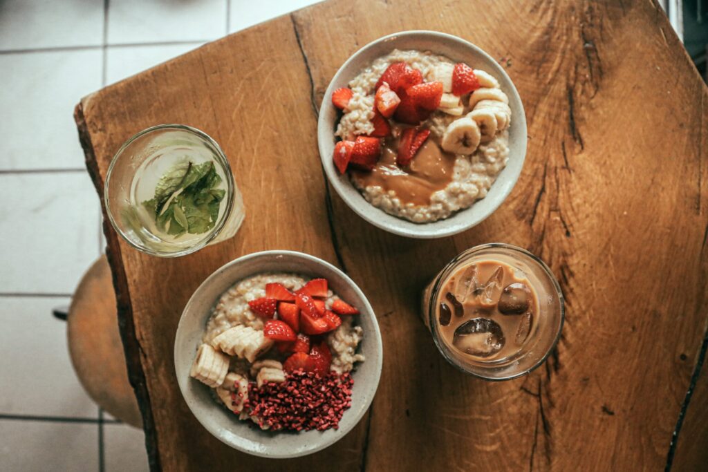 Two Bowls of Oatmeal Cover in Strawberries, Bananas, & Peanut Butter